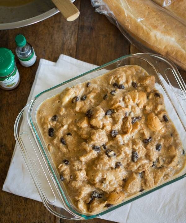 Bread pudding with hot butter rum sauce in a clear baking dish.
