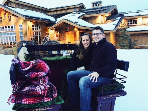 Man and woman in a sled pulled by horses.