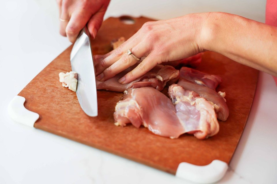 Trimming the fat off the chicken thigh